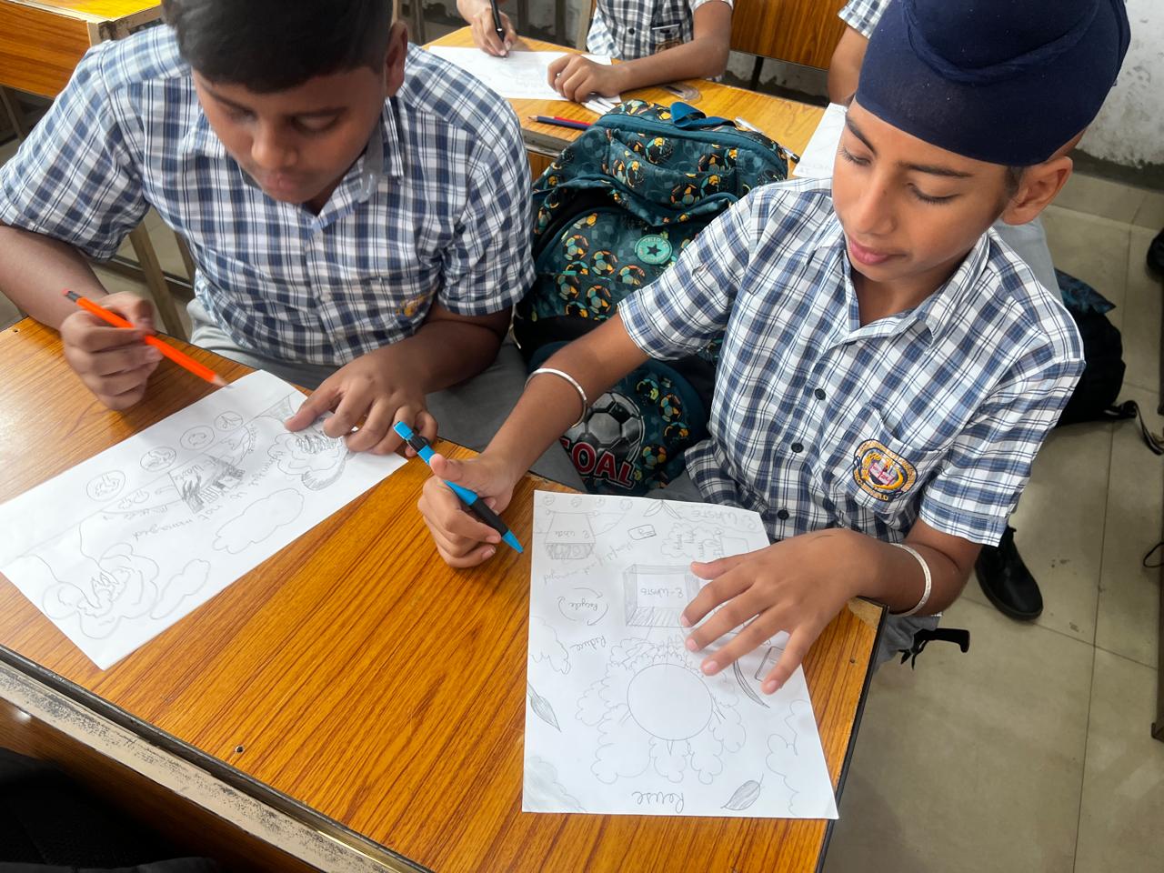 Student drawing an e-waste awareness poster